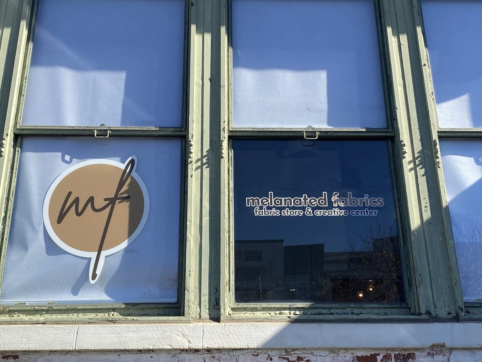 Cute little storefront logo and sign at Melanated Fabrics