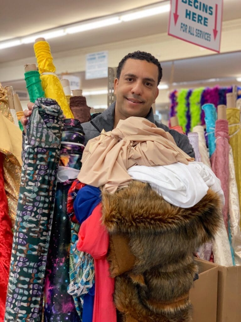 Gentleman holding faux fabric in a fabric store