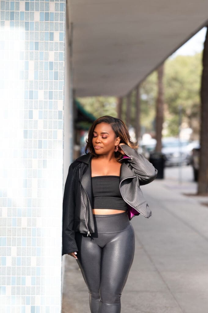 African American Women standing on the sidewalk in spanx wearing McCalls 8121 moto jacket