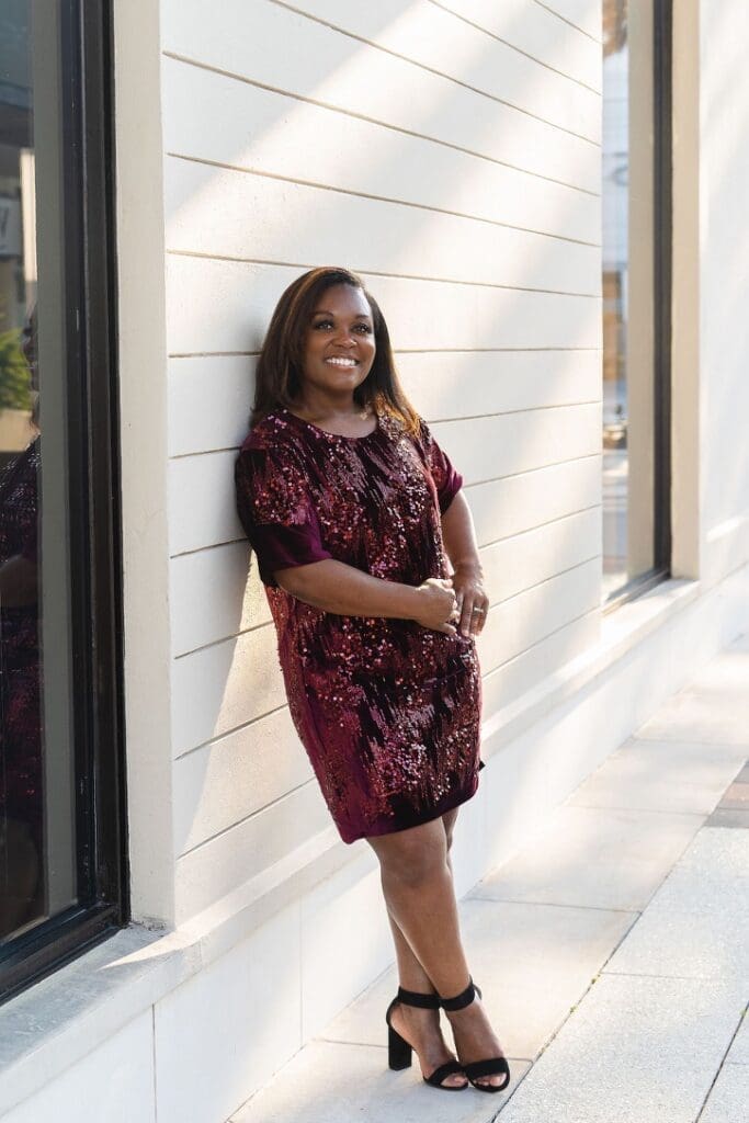 black women leaning on wall in McCalls 8160 red sequin shift dress