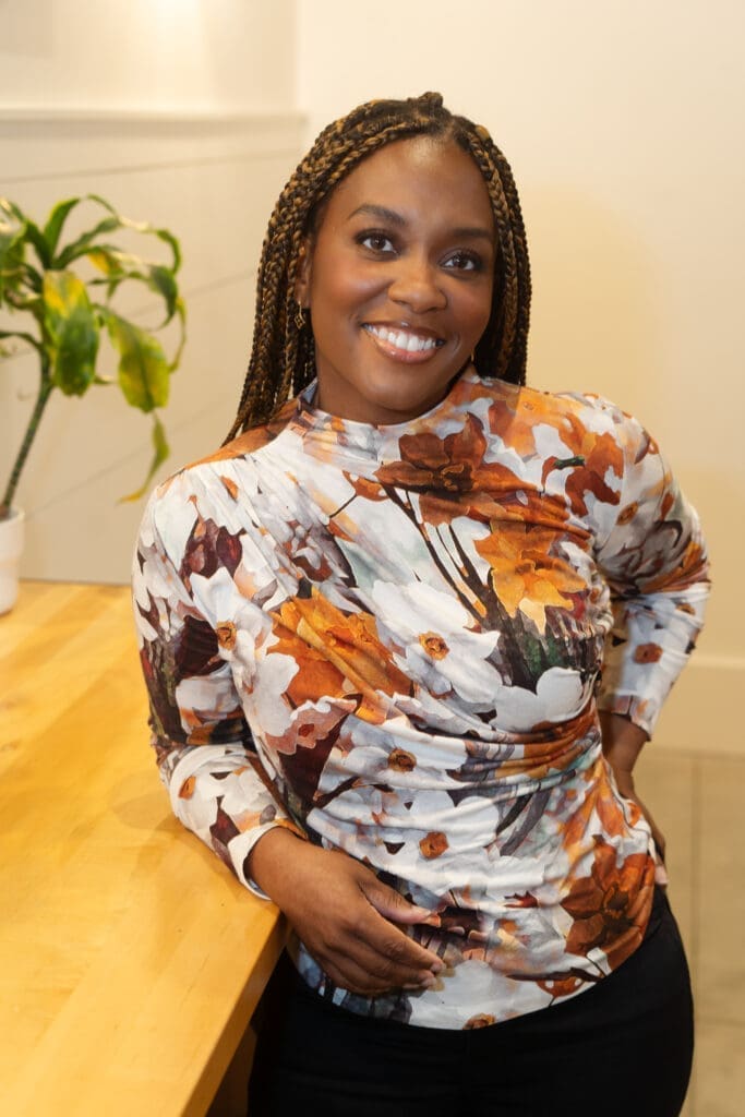 African American woman standing near a wooden table wearing Simplicity 9451