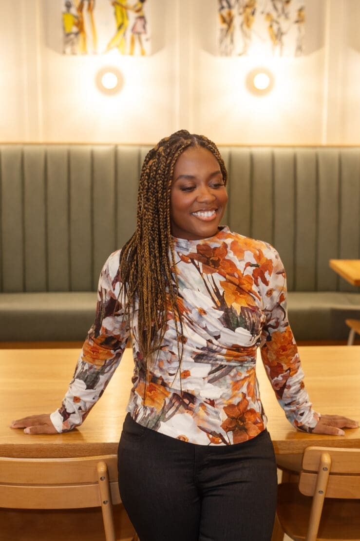 African American woman standing near a wooden table wearing Simplicity 9451
