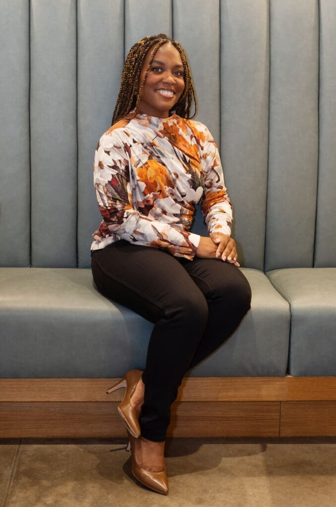 African American woman seated on a green bench wearing Simplicity 9451