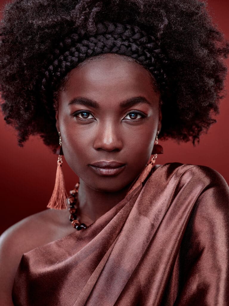 Beautiful black women stares into the camera with a crown halo of cornrows and loose afro of natural hair