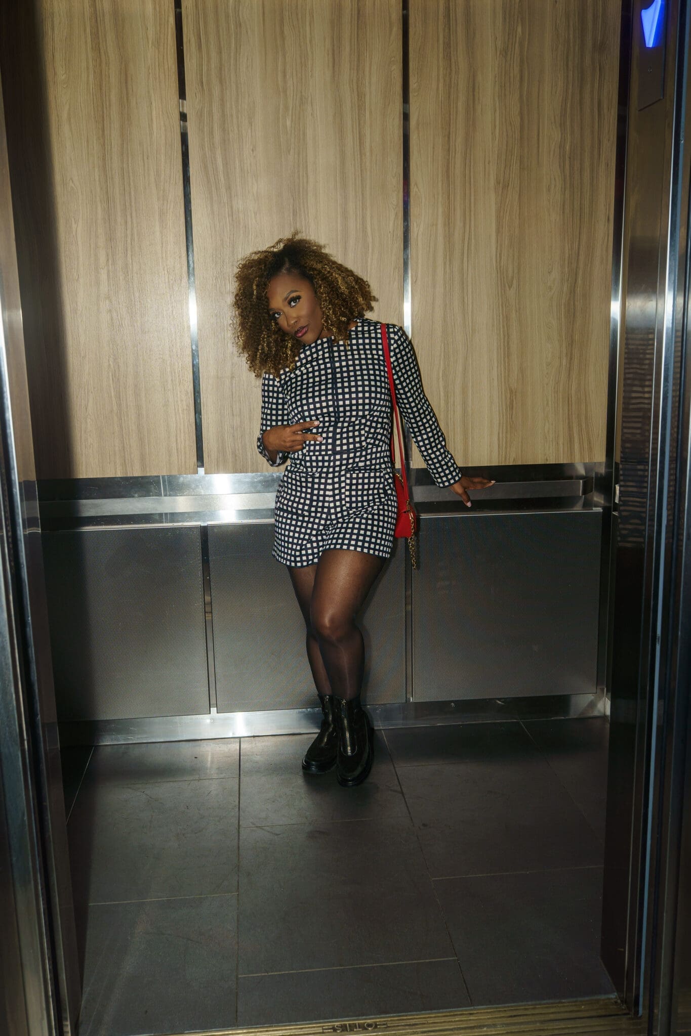 Sophisticated romper outfit for women over 40 styled with semi-sheer tights and chunky boots