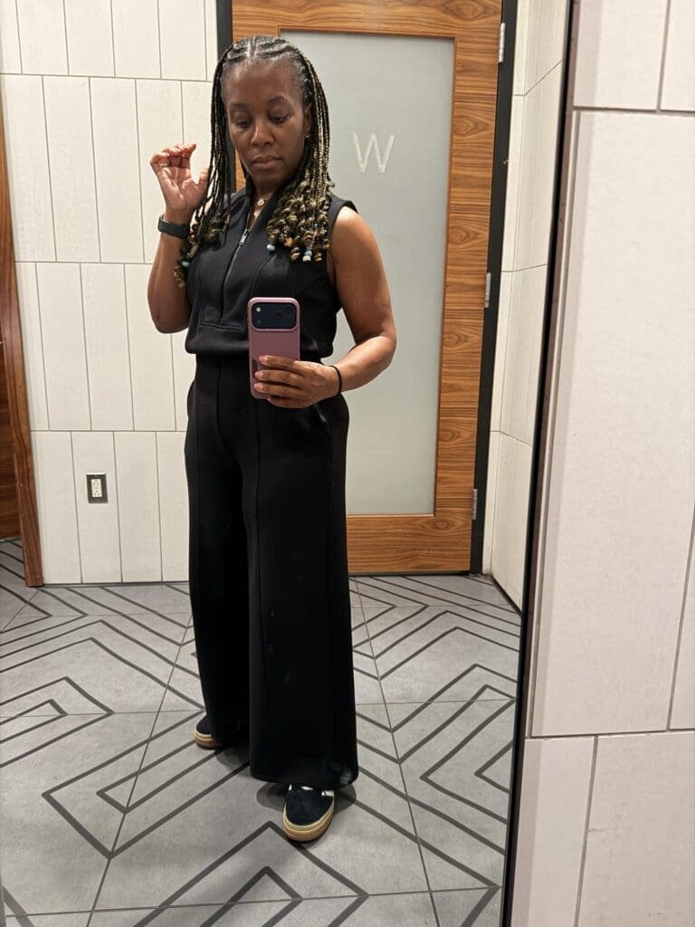 Restroom selfie showcasing the flattering fit of the Spanx AirEssentials Jumpsuit on a petite frame.